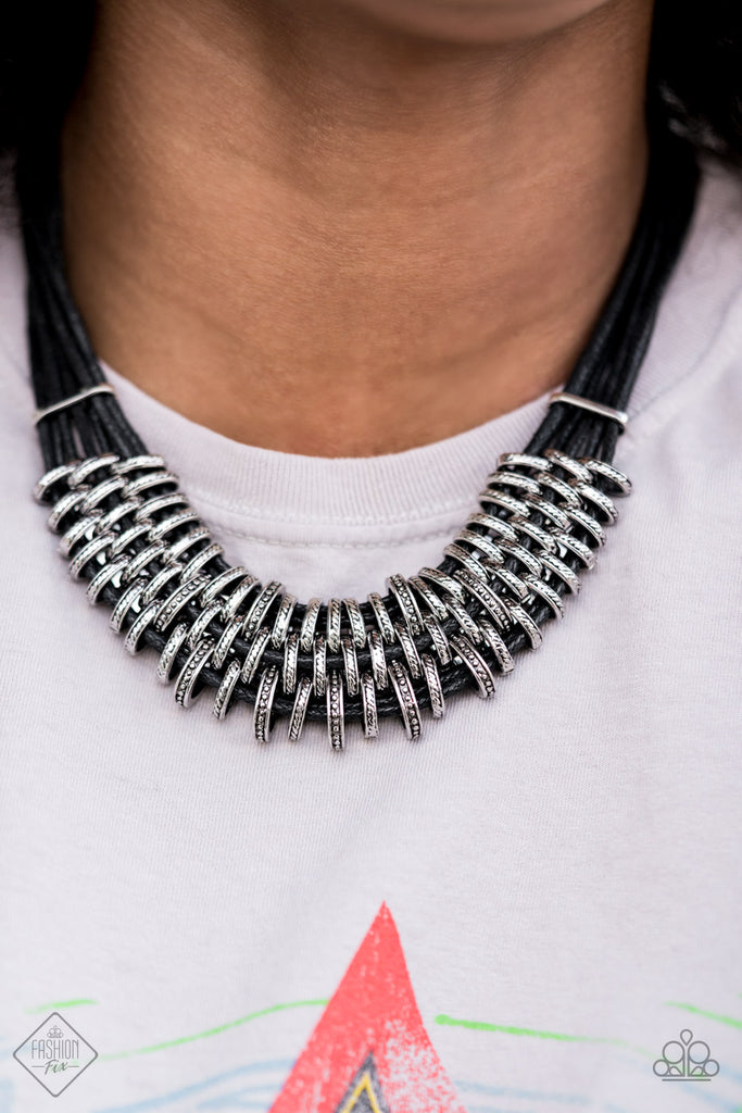 Bold and unapologetic, this hefty necklace gives off a hand-made feel with its multiple strands of black cording held together by industrial silver fittings that shift and slide. Features an adjustable clasp closure.  Sold as one individual necklace. Includes one pair of matching earrings.