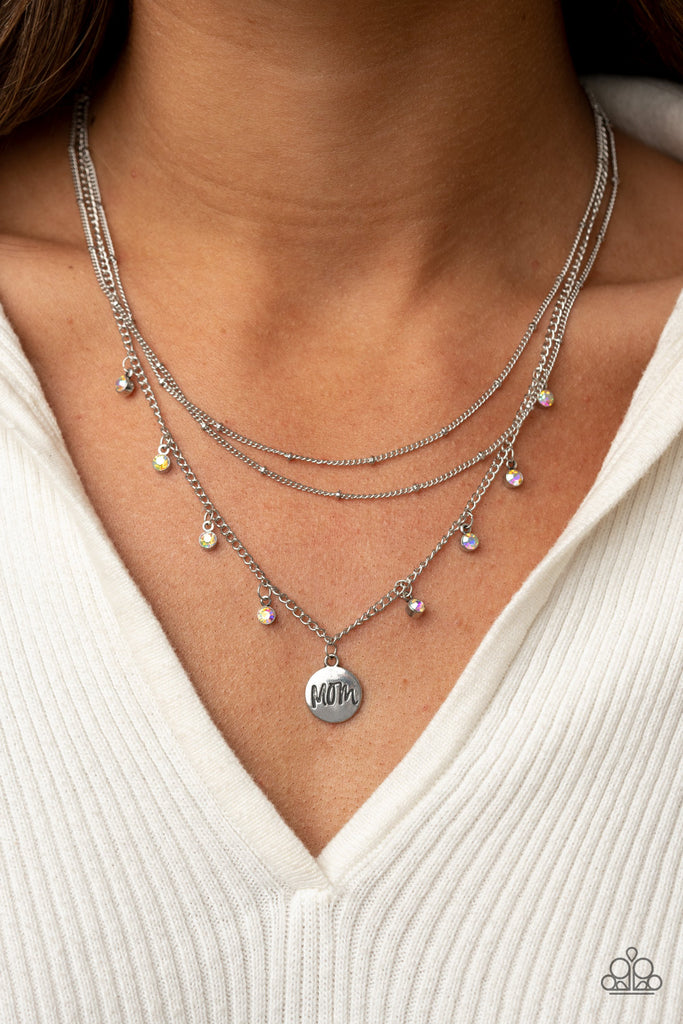 A petite silver disc engraved with the word "Mom," sweetly swings from the bottom of a silver chain accented with sparkly iridescent rhinestones. Layers of silver satellite chain add charisma as they combine to fall below the collar for a timeless finish. Features an adjustable clasp closure.  Sold as one individual necklace. Includes one pair of matching earrings.