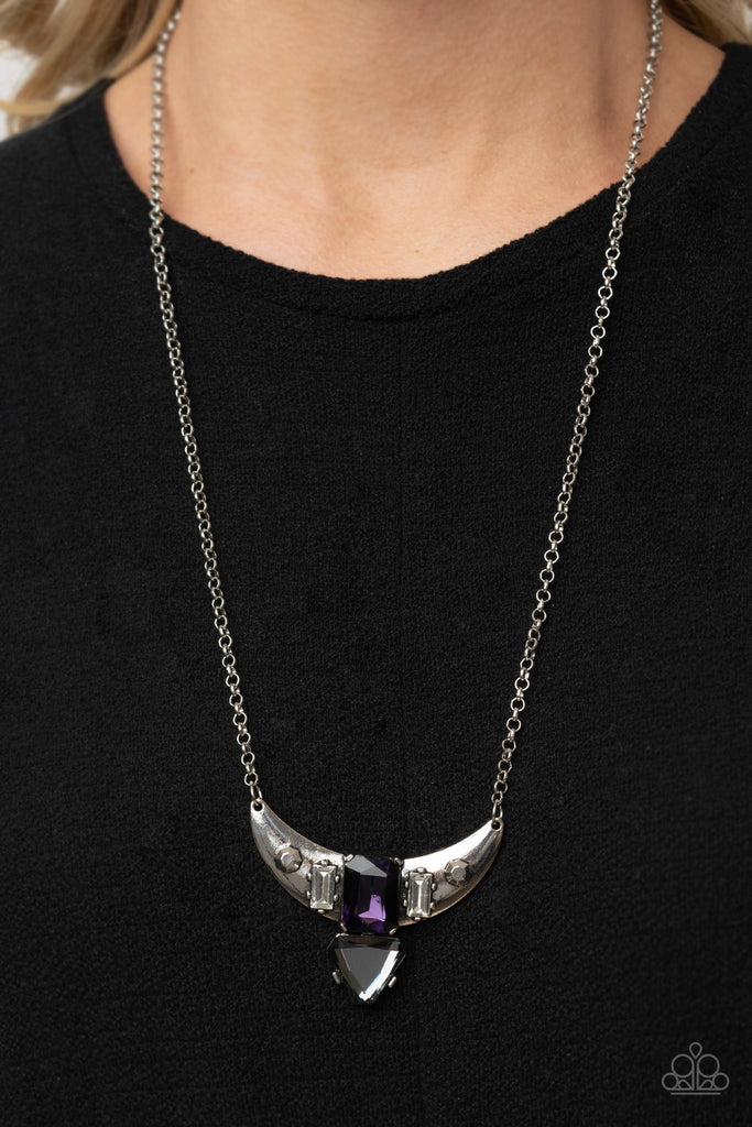 Pairs of faceted silver beads and glassy white emerald cut gems flank an oversized emerald cut purple gem atop an antiqued silver half moon frame. A smoky triangular cut gem adorns the bottom of the pendant, creating a twinkly talisman at the bottom of a classic silver chain. Features an adjustable clasp closure.  Sold as one individual necklace. Includes one pair of matching earrings.