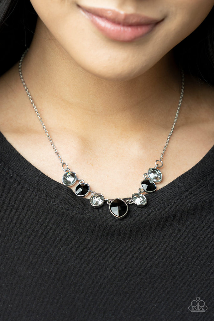 Encased in sleek silver fittings, elegant cut smoky and black rhinestones delicately connect below the collar. An oversized black rhinestone adorns to the middle of the glittery strand, creating a sparkly centerpiece. Features an adjustable clasp closure.  Sold as one individual necklace. Includes one pair of matching earrings.