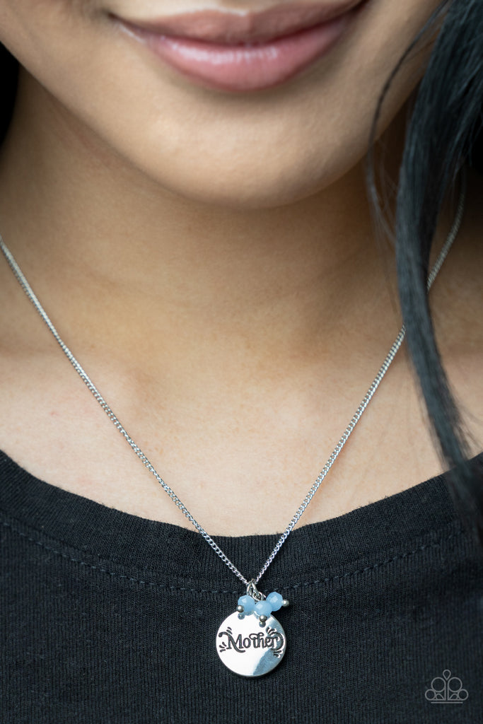 A dainty cluster of opaque Cerulean beads delicately joins a shiny silver disc stamped in the word, "Mother," along a classic silver chain, creating a whimsical pendant below the collar. Features an adjustable clasp closure.  Sold as one individual necklace. Includes one pair of matching earrings.  
