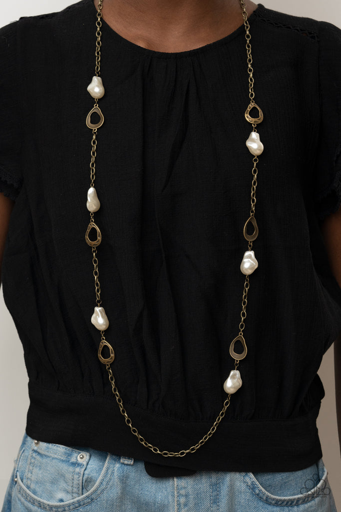 Asymmetrical hammered brass frames and imperfect pearly accents link with sections of antiqued brass chains across the chest, creating a rustic and refined statement piece. Features an adjustable clasp closure.  Sold as one individual necklace. Includes one pair of matching earrings.