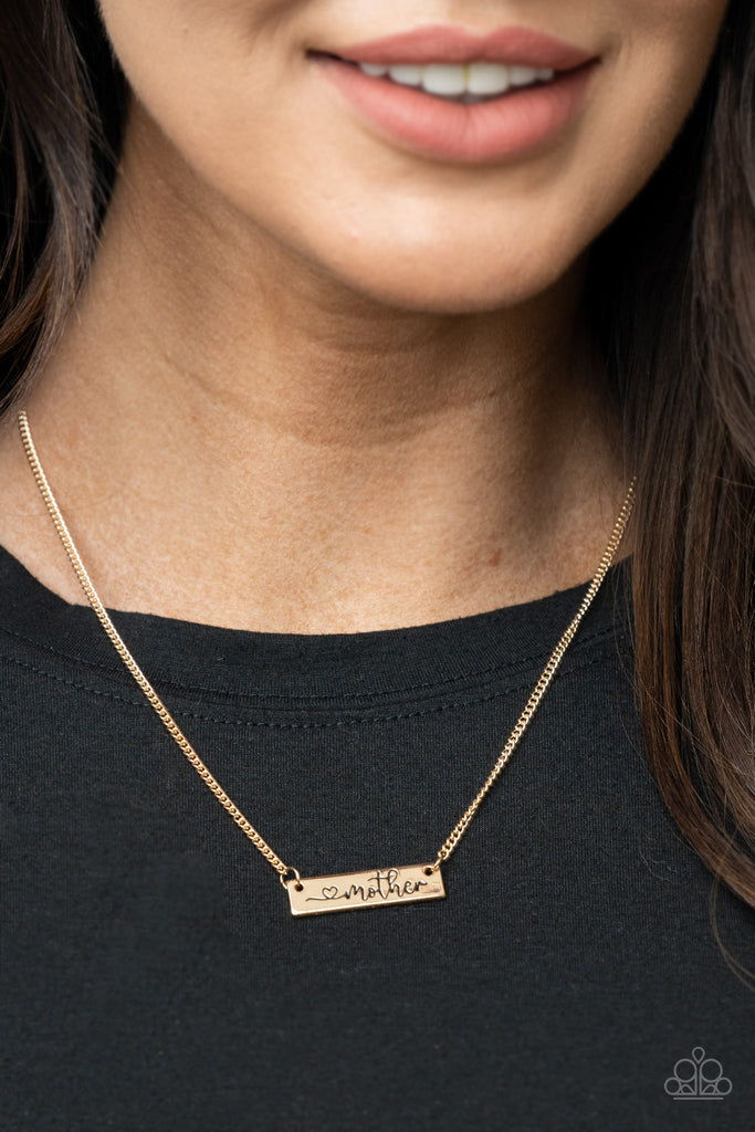 Stamped in a heart and the word, "Mother," a glistening gold plate is suspended by a classic gold chain below the collar, creating a whimsy sentimental pendant. Features an adjustable clasp closure.  Sold as one individual necklace. Includes one pair of matching earrings.