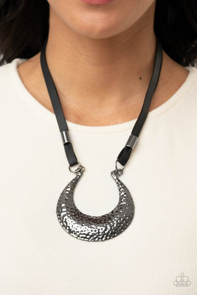 Infused with glistening gunmetal beads, strips of black leather link to an oversized half moon pendant that is hammered in a blinding gunmetal finish, creating an edgy statement piece below the collar. Features an adjustable clasp closure.  Sold as one individual necklace. Includes one pair of matching earrings.