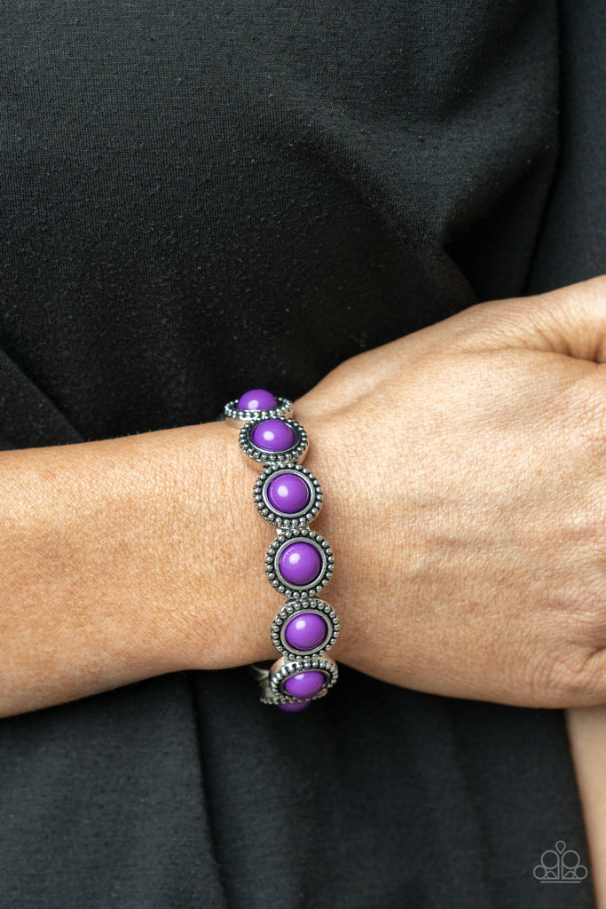 Featuring an antiqued silver studded edge, silver frames encase polished purple beads. The eye-catching series of fanciful beads are threaded along a stretchy band and promenade around the wrist for a whimsical look.  Sold as one individual bracelet.