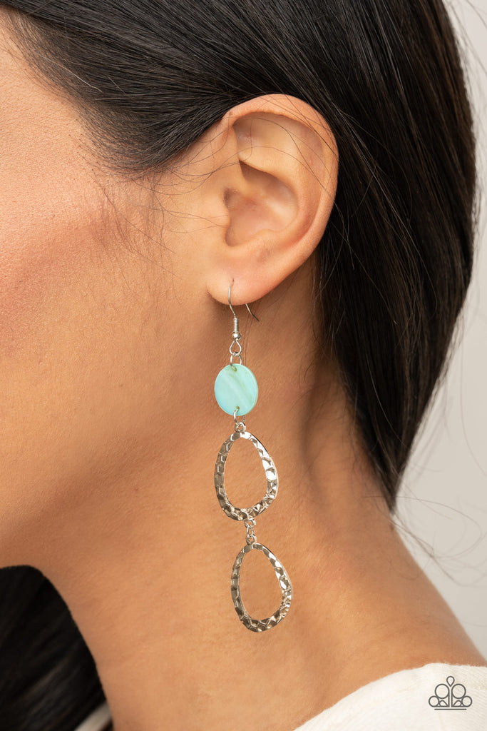 A pearly blue shell disc anchors to two shiny hammered silver asymmetrical hoops as they dangle from the ear creating a dazzling lure. Earring attaches to a standard fishhook fitting.  Sold as one pair of earrings.