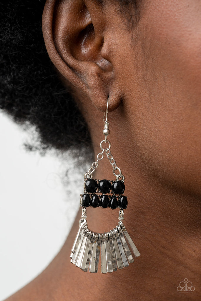 A row of delicately hammered silver rods fans out along a dainty silver wire that attaches to the bottom of stacked rows of shining black beads. The mismatched rows of beads swing from the bottom of dainty silver chains, coalescing into an ethereally rustic chandelier. Earring attaches to a standard fishhook fitting.  Sold as one pair of earrings.