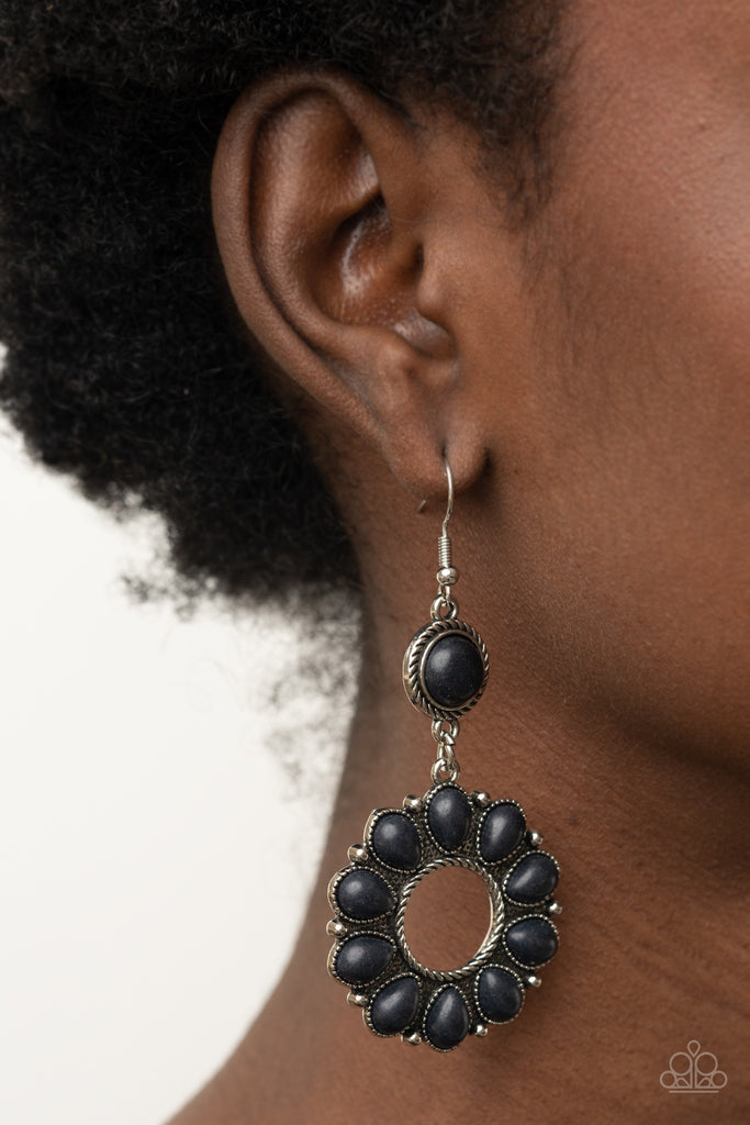 An earthy collection of black teardrop stones fans out from a textured silver ring, creating a scalloped floral frame dangling from a round black stone encased in a braided silver fitting. Earring attaches to a standard fishhook fitting.  Sold as one pair of earrings.  