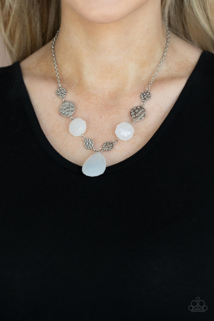 A dewy white teardrop swings from the bottom of interlinking hammered silver discs and matching dewy white crystal-like beads, creating a dreamy display below the collar. Features an adjustable clasp closure.  Sold as one individual necklace. Includes one pair of matching earrings.  