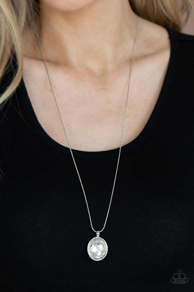 An oversized white gem is pressed into the center of a sleek silver fitting, creating a mesmerizing statement piece at the bottom of a sleek silver chain. Features an adjustable clasp closure.  Sold as one individual necklace. Includes one pair of matching earrings.  New Kit