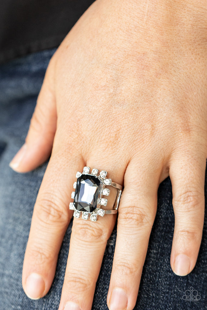 Featuring dainty silver square fittings, an explosion of glassy white rhinestones fans out from a dramatically oversized emerald cut smoky rhinestone center, creating a stellar centerpiece atop the finger. Features a stretchy band for a flexible fit.  Sold as one individual ring.  