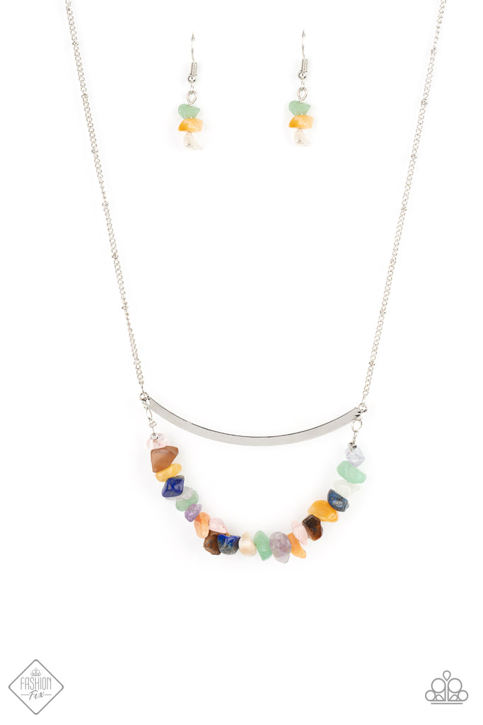 pebble-prana A row of raw cut multicolored rocks are threaded along a dainty wire that bows at the bottom of a curved silver bar, creating an earthy pendant. The colorfully stacked frame swings from the bottom of a lengthened silver satellite chain for a glamorously grounding effect. Features an adjustable clasp closure.  Sold as one individual necklace. Includes one pair of matching earrings.
