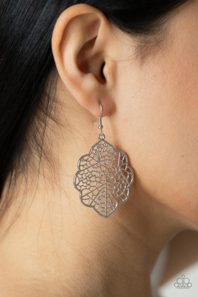 A scalloped silver leafy frame is filled with a backdrop of stenciled geometric accents, creating a whimsy seasonal display. Earring attaches to a standard fishhook fitting.  Sold as one pair of earrings.