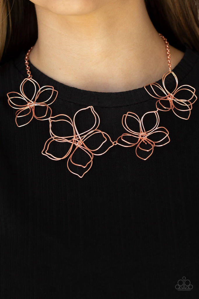 Shiny copper wire delicately twists into oversized blossoms. Varying in size, the airy floral frames delicately link into an asymmetrical display as the layered frames elegantly pop beneath the collar. Features an adjustable clasp closure.  Sold as one individual necklace. Includes one pair of matching earrings.