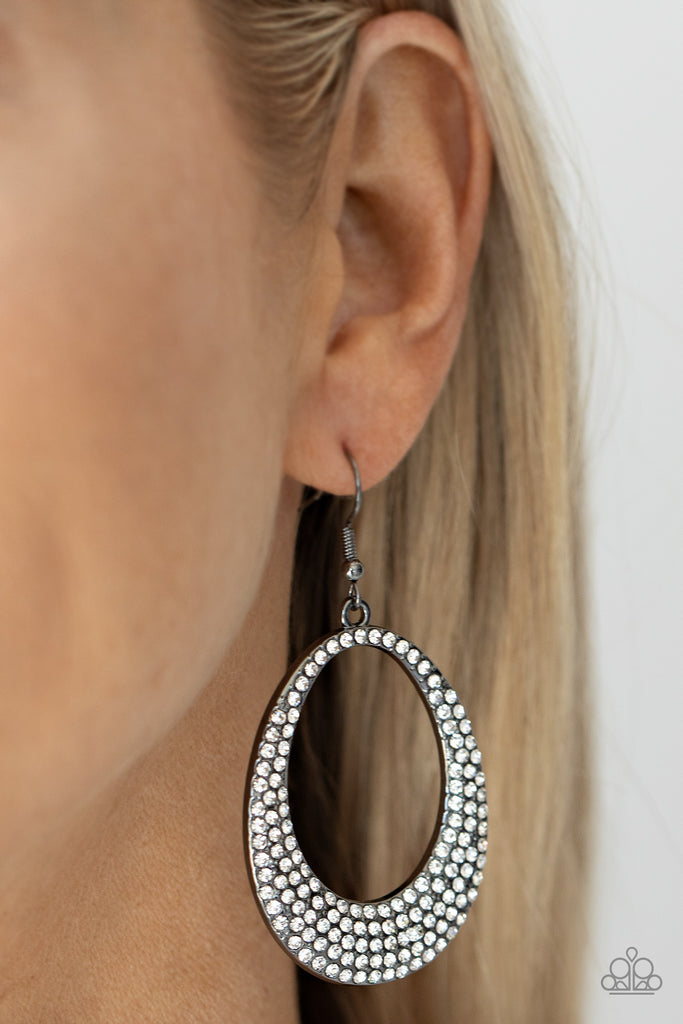 Shiny gunmetal oval frames with airy cut-out centers, are covered in brilliant white rhinestones, creating an enchanting lure. Earring attaches to a standard fishhook fitting.  Sold as one pair of earrings.