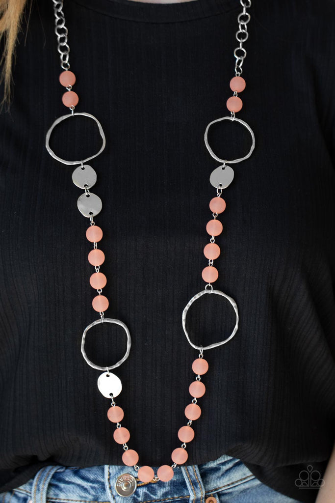 Connecting to strands of basic silver links, cloudy Burnt Coral beads alternate with hammered silver discs and oversized rings creating a subtle seaside vibe as they fall across the chest. Features an adjustable clasp closure.  Sold as one individual necklace with one pair of matching earrings.
