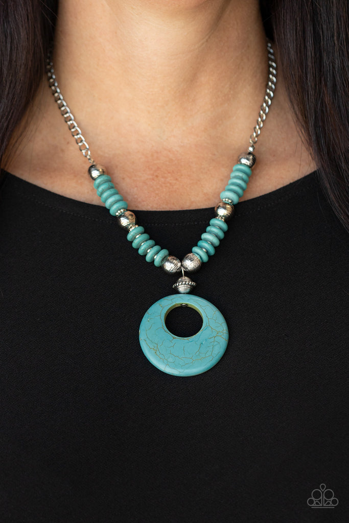 Infused with dainty silver accents, mismatched silver beads and turquoise stone discs are threaded along an invisible wire below the collar. An oversized turquoise stone pendant swings from the center of the earthy strand, creating a bold pop of seasonal inspiration. Features an adjustable clasp closure.  Sold as one individual necklace.