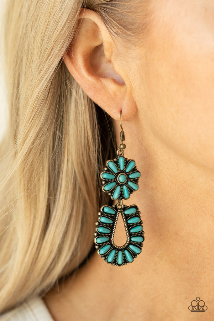 Infused with studded brass fittings, two turquoise stone frames connect into a squash blossom for an authentically southwestern inspired look. Earring attaches to a standard fishhook fitting.  Sold as one pair of earrings.