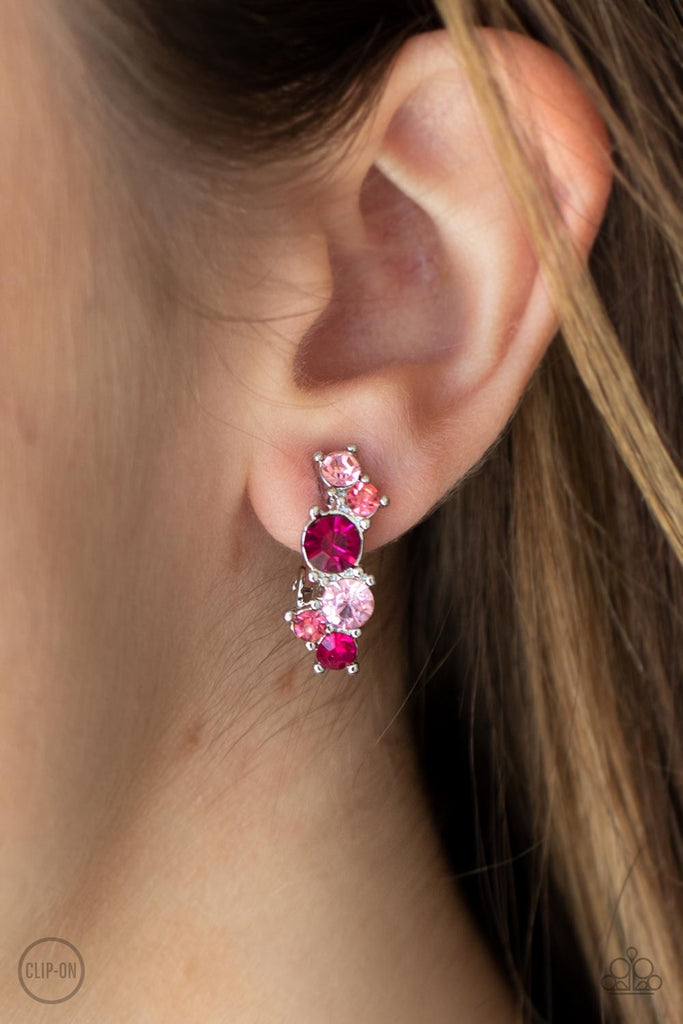 Varying in shades of pink, mismatched rhinestones delicately coalesce into a dainty frame for a colorfully sparkly display. Earring attaches to a standard clip-on fitting.  Sold as one pair of clip-on earrings.