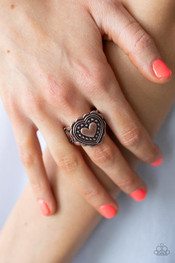 Scalloped in frilly detail, a studded copper heart frame sits atop two rustic copper bands for a romantically rustic look. Features a stretchy band for a flexible fit.  Sold as one individual ring.