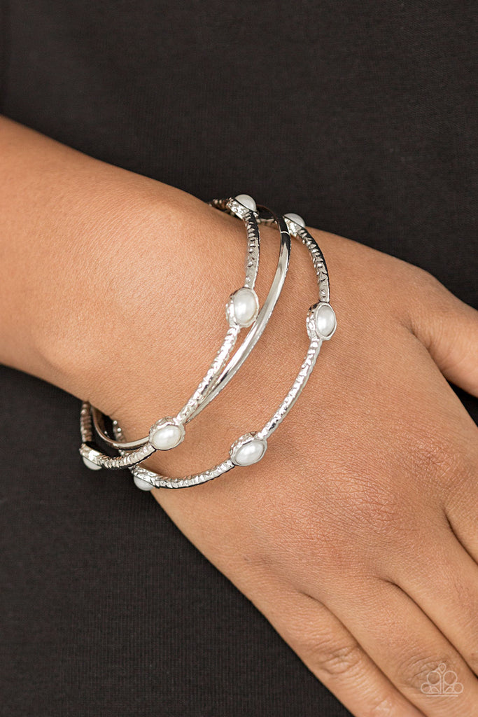 Delicately hammered in shimmer, a pair of pearly encrusted bangles joins a smooth silver bangle around the wrist for a refined fashion.  Sold as one set of three bracelets.