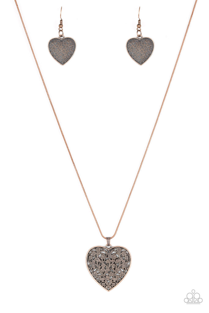 Filled with vine-like filigree detail, a copper heart pendant swings below the collar for a vintage inspired look. Features an adjustable clasp closure.  Sold as one individual necklace. Includes one pair of matching earrings.