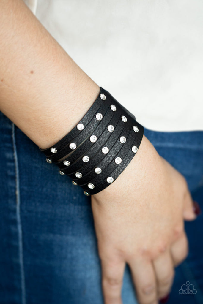 A thick black leather band has been spliced into numerous black strands. Featuring sleek silver frames, glittery white rhinestones are sprinkled across the leather bands for a sassy finish. Features an adjustable snap closure.  Sold as one individual bracelet.