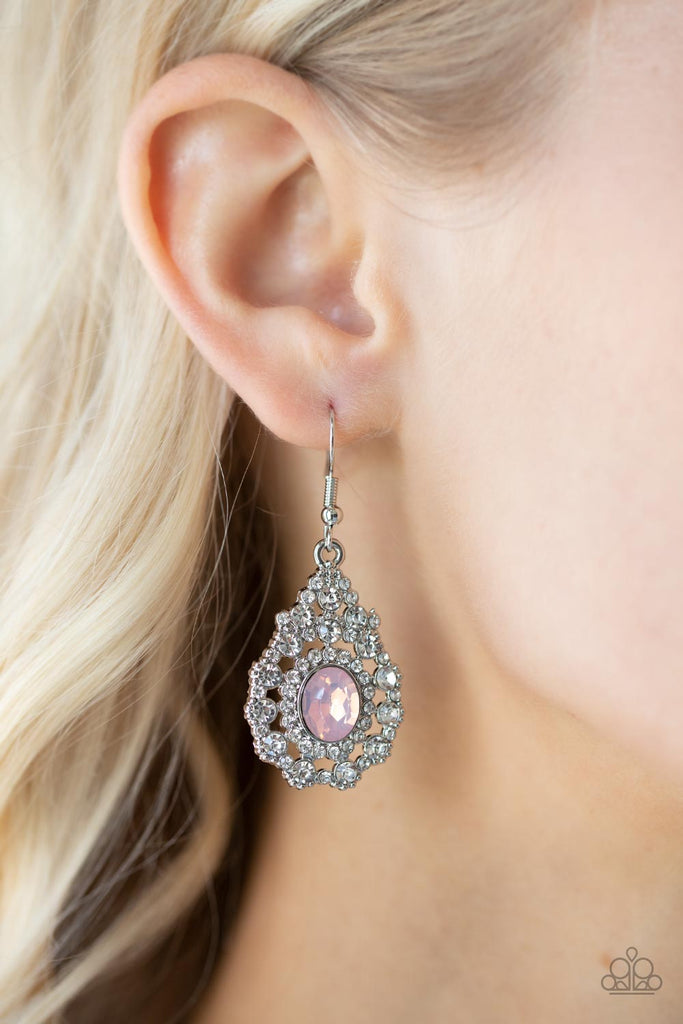 Bordered in a ring of dainty white rhinestones, an opalescent pink gem adorns the center of a teardrop frame radiating with glassy white rhinestones for an ethereally elegant look. Earring attaches to a standard fishhook fitting.  Sold as one pair of earrings.