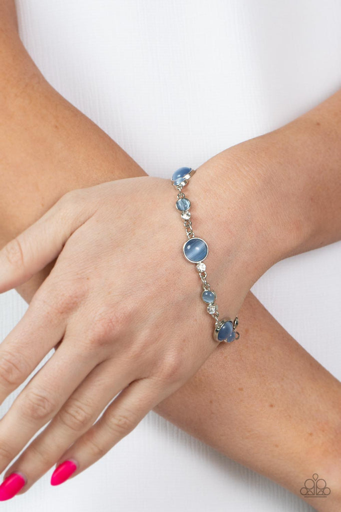 Encased in sleek silver fittings, a bubbly collection of blue cat's eye stones and glassy white rhinestones coalesce into mismatched frames that delicately connect around the wrist for an effervescent elegance. Features an adjustable clasp closure.  Sold as one individual bracelet.