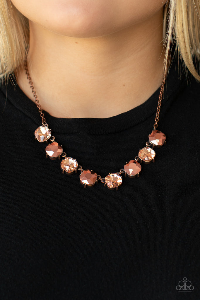 A coppery palette of glitzy aurum and classic rhinestones, set in antiqued copper pronged fittings, creates sparkle and shine as they dance below the collar. Features an adjustable clasp closure.  Sold as one individual necklace. Includes one pair of matching earrings.  