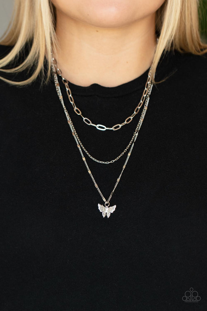 Dotted with a dainty white rhinestone, a decoratively layered silver butterfly swings from the bottom of a display of mismatched silver chains for a whimsically fluttering fashion. Features an adjustable clasp closure.  Sold as one individual necklace. Includes one pair of matching earrings.  