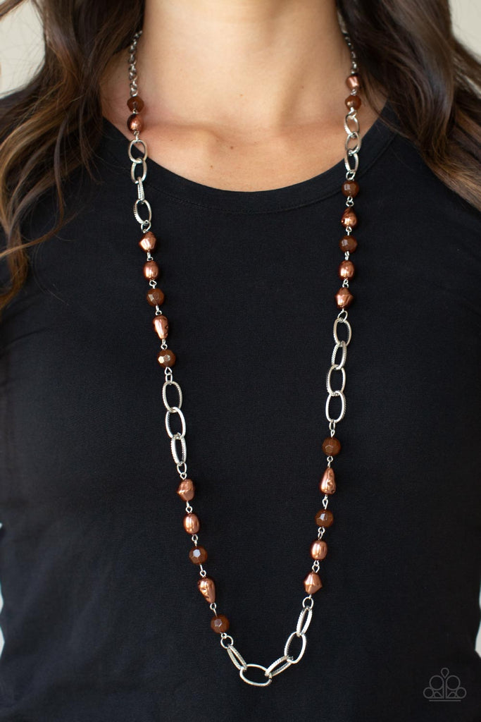 tea-party-tango-brown  Featuring imperfectly faceted and hammered finishes, pearly brown teardrop and round beads join opaque brown crystal-like accents along sections of chunky silver chain across the chest for a glamorous look. Features an adjustable clasp closure.  Sold as one individual necklace. Includes one pair of matching earrings.
