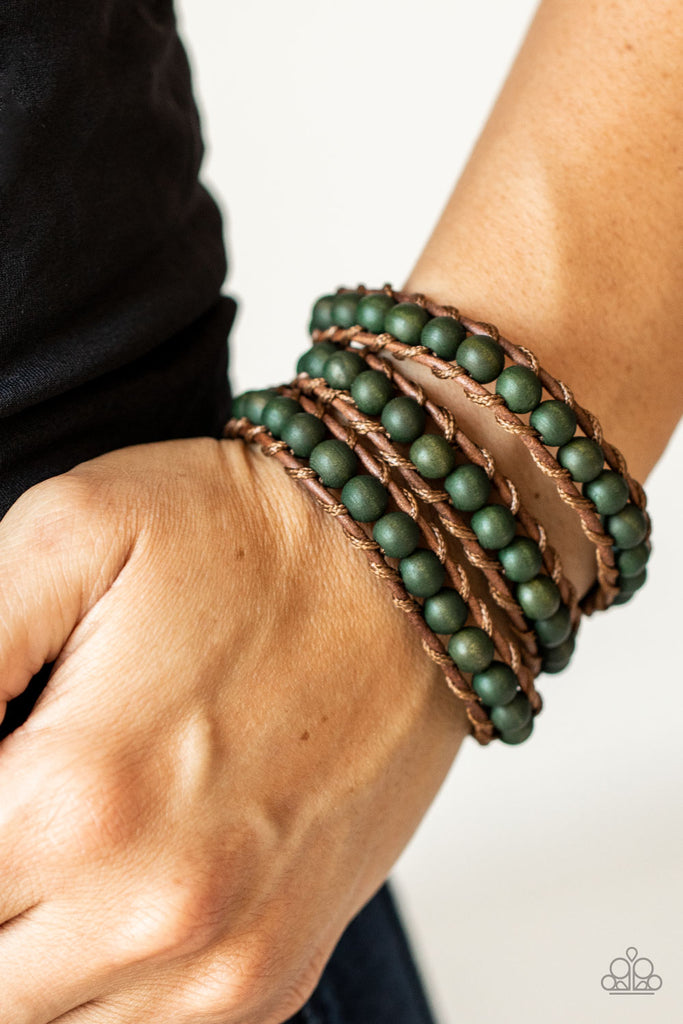 A row of green wooden beads are knotted in place along two brown leather cords, creating multiple earthy layers around the wrist with its extended length. Features an adjustable button loop closure.  Sold as one individual bracelet.  
