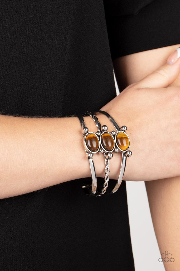 Featuring silver studded fittings, an earthy trio of oval tiger's eye stones adorn the center of an ornately layered silver cuff for a seasonal finish.  Sold as one individual bracelet.