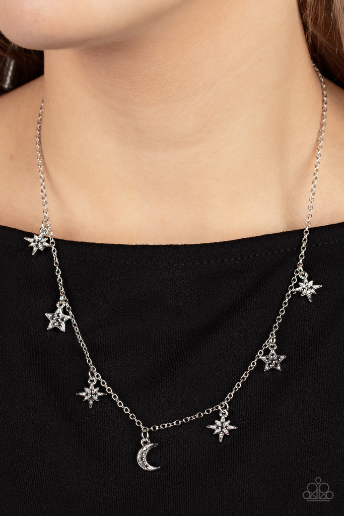 Dotted with dainty hematite rhinestones, a stellar collection of silver moon and star charms swing from a dainty silver chain below the collar, creating a cosmic fringe. Features an adjustable clasp closure.  Sold as one individual necklace. Includes one pair of matching earrings.