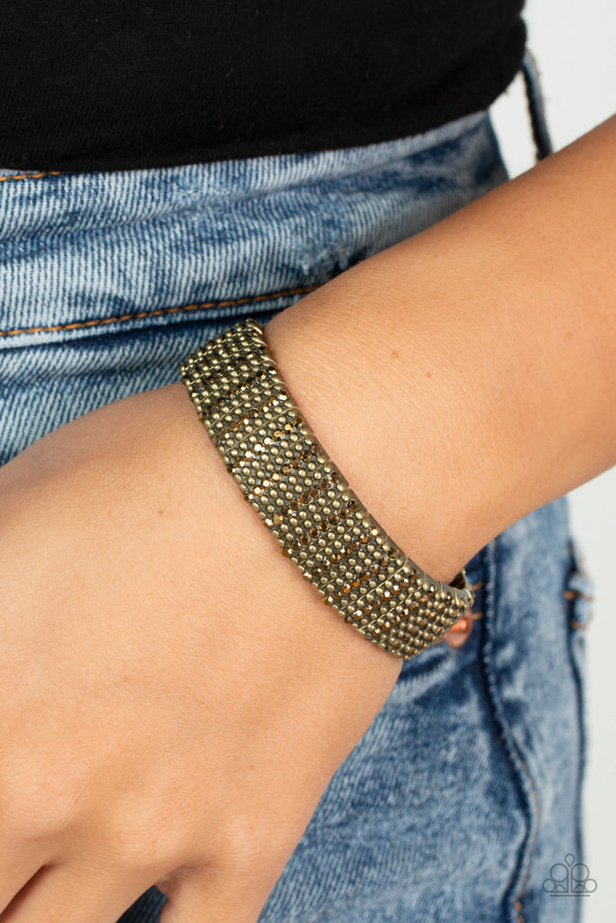 Flanked by dainty brass studs, aurum rhinestone dotted brass frames are threaded along stretchy bands around the wrist for a gritty glamorous look.  Sold as one individual bracelet.