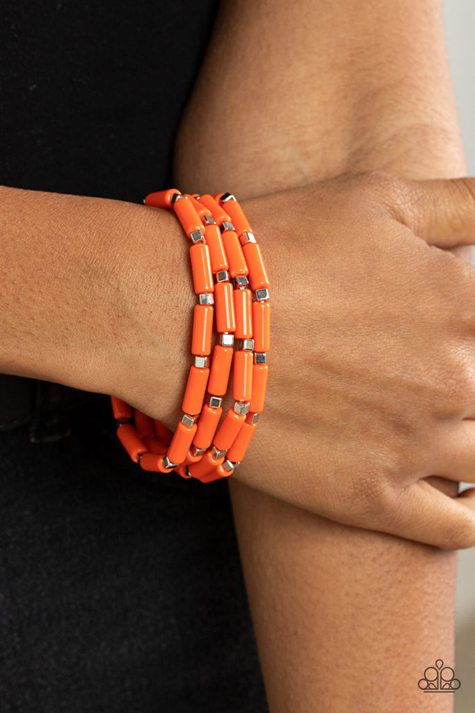 A playful collection of dainty silver cube beads and cylindrical orange beads are threaded along stretchy bands, creating colorful layers around the wrist.  Sold as one set of four bracelets.