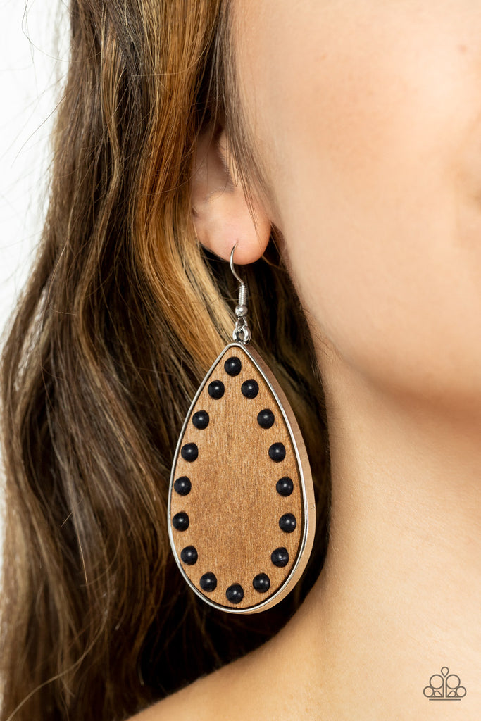 Dainty black stone beads border an earthy wooden teardrop frame that is encased in a sleek silver fitting, creating a whimsical woodsy lure. Earring attaches to a standard fishhook fitting.  Sold as one pair of earrings.