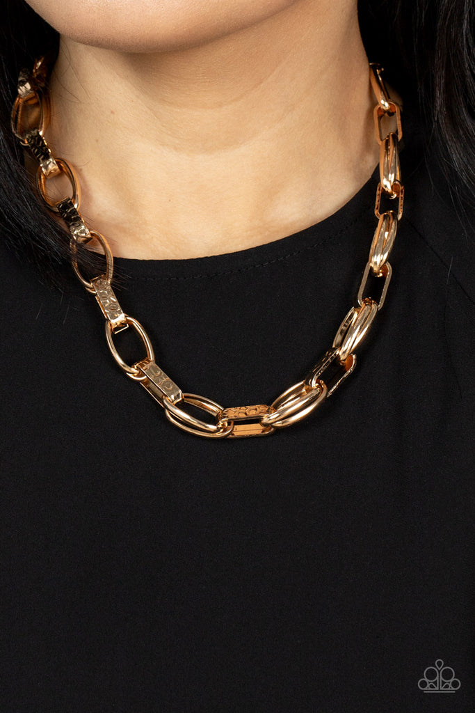 Wide hammered gold links alternate with double sets of shiny gold links as they connect across the collar for an edgy industrial effect. Features an adjustable clasp closure.  Sold as one individual necklace. Includes one pair of matching earrings.