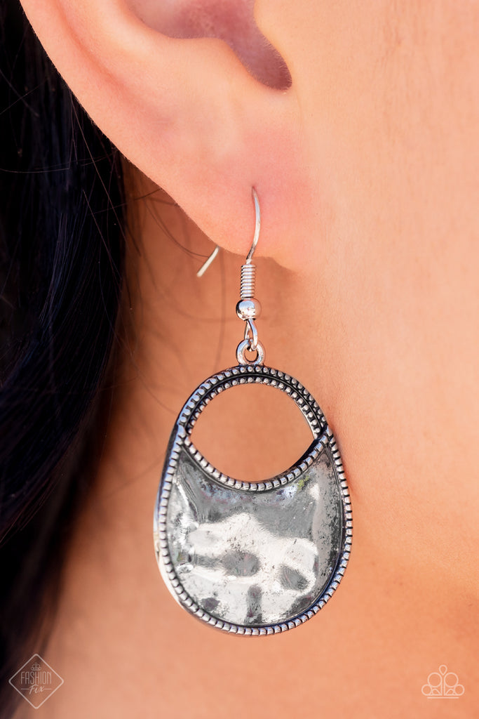 A daintily dotted wide oval silver frame is partially filled with a high sheen hammered silver, leaving an airy cutout at the top for a polished finish. Earring attaches to a standard fishhook fitting.  Sold as one pair of earrings.
