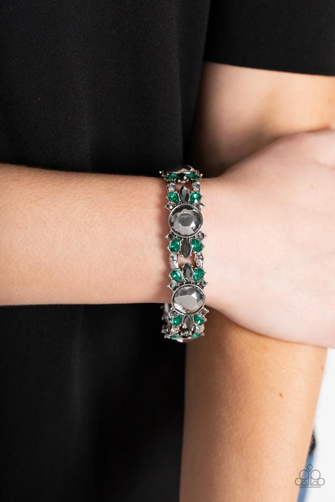 Green teardrop and round and marquise cut hematite rhinestones flare out from a faceted silver beaded center, coalescing into glitzy frames. The gorgeous frames are threaded along stretchy bands around the wrist, resulting in a sassy centerpiece.  Sold as one individual bracelet.