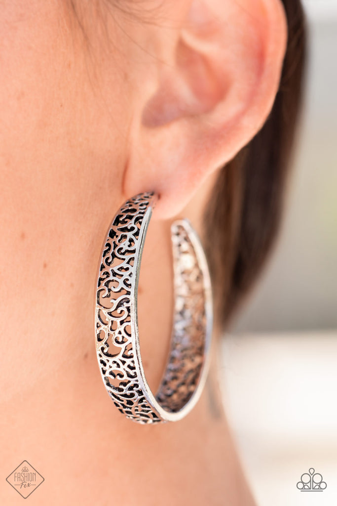 Whimsical swirls of antiqued silver filigree flow wildly within simple silver frames to create an intricate hoop. Earring attaches to a standard post fitting. Hoop measures approximately 2" in diameter.  Sold as one pair of hoop earrings.