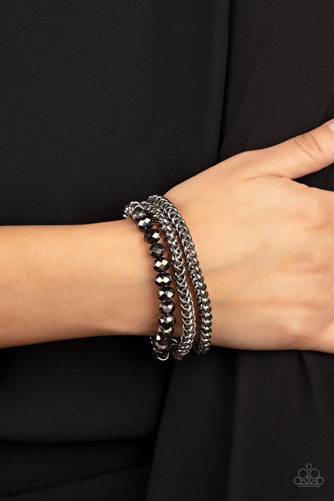 Threaded along stretchy bands, sections of hematite crystal-like beads and interlocking silver chains layer around the wrist for a dash of glitzy grunge.  Sold as one set of three bracelets.