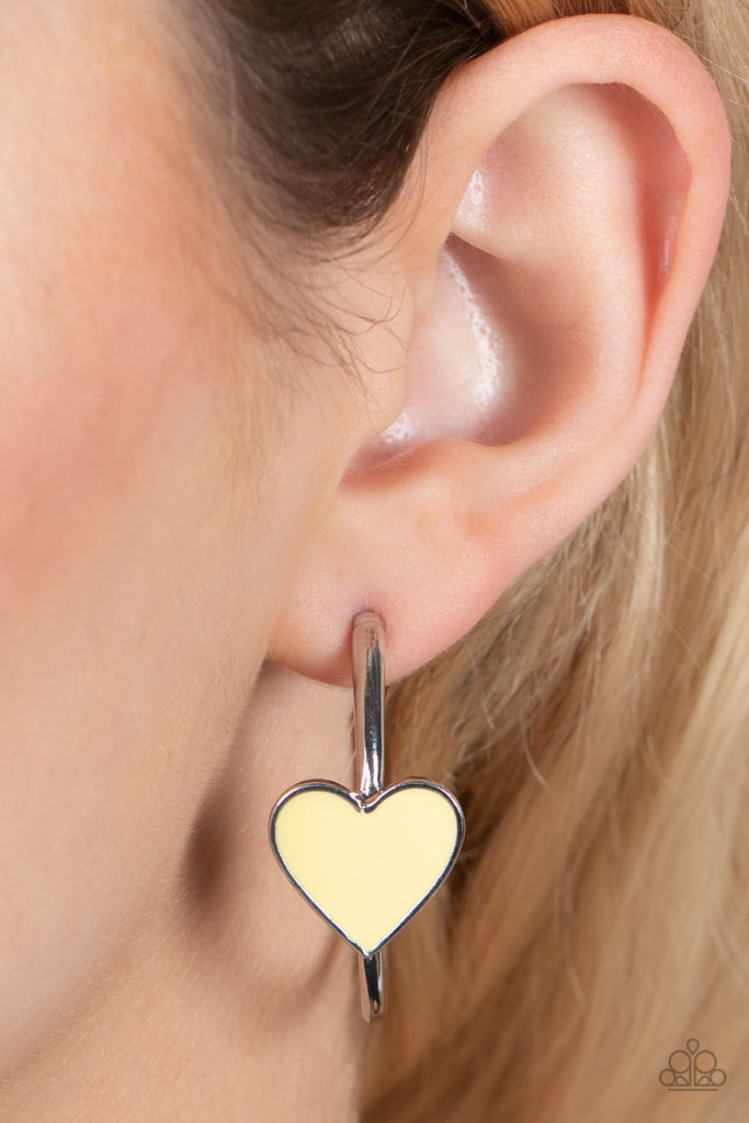 A charming Illuminating heart adorns the front of a classic silver hoop resulting in a whimsical fashion. Earring attaches to a standard post fitting. Hoop measures approximately 1 1/4" in diameter.  Sold as one pair of hoop earrings.  