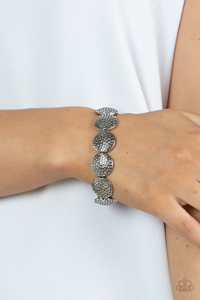 Hammered in antiqued details, a rustic collection of silver beads are threaded along a stretchy band around the wrist for a wildly adventurous look.  Sold as one individual bracelet.