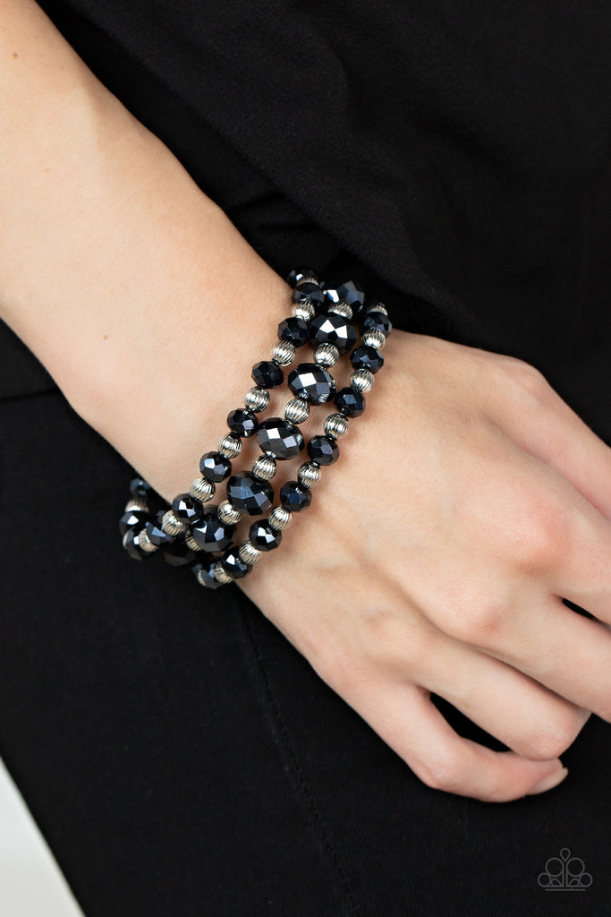 Varying in size, and explosion of metallic blue crystal-like gems and ornate silver beads are threaded along stretchy bands around the wrist for a glamorous fashion.  Sold as one set of three bracelets.