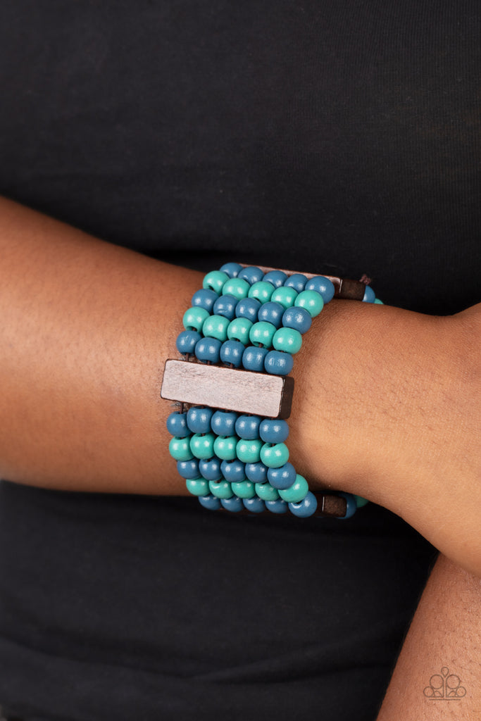 Colorful layers of blue and turquoise wooden beads are threaded along stretchy bands between dark brown wooden bars creating stacks of subtle bliss around the wrist.  Sold as one individual bracelet.