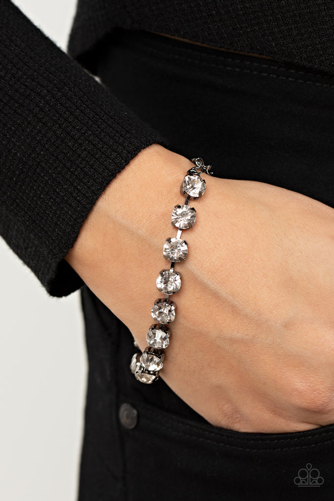 Featuring pronged gunmetal fittings, an oversized row of glassy white rhinestones connect around the wrist for a glamorous pop of glitz. Features an adjustable clasp closure.  Sold as one individual bracelet.