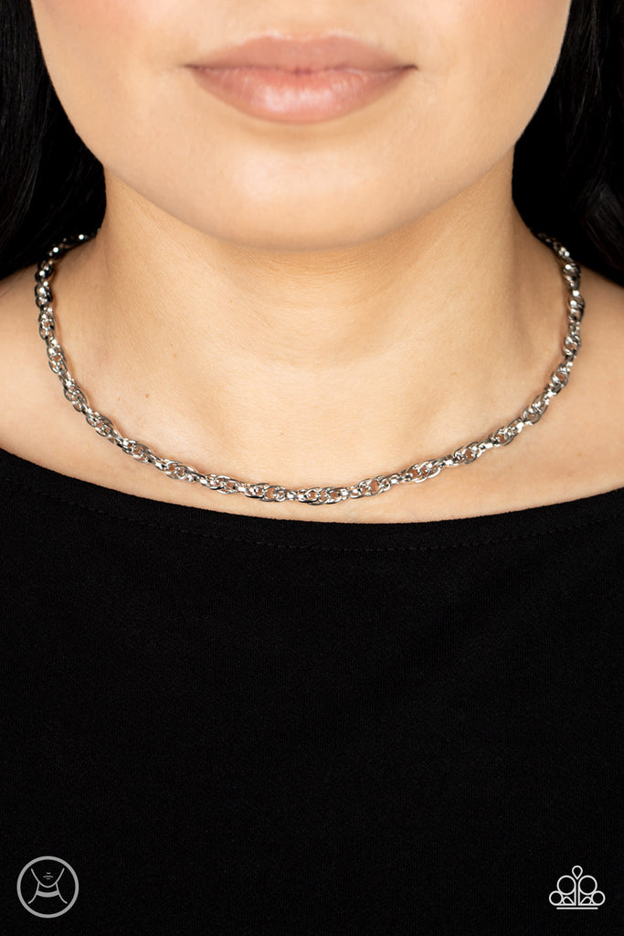 An ornately linked silver chain wraps around the neck, resulting in an edgy minimalist inspired grit. Features an adjustable clasp closure.  Sold as one individual choker necklace. Includes one pair of matching earrings.