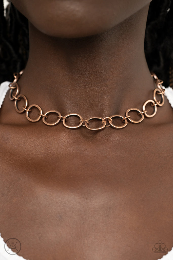 Brushed in an antiqued finish, imperfectly shaped copper circles link together for a gritty industrial statement. Features an adjustable clasp closure.  Sold as one individual choker necklace. Includes one pair of matching earrings.